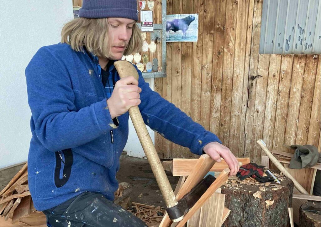 Mann beim Holzsschindel klieben